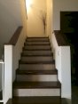 Dark wood staircase leading upstairs to the bedrooms and downstairs to the basement